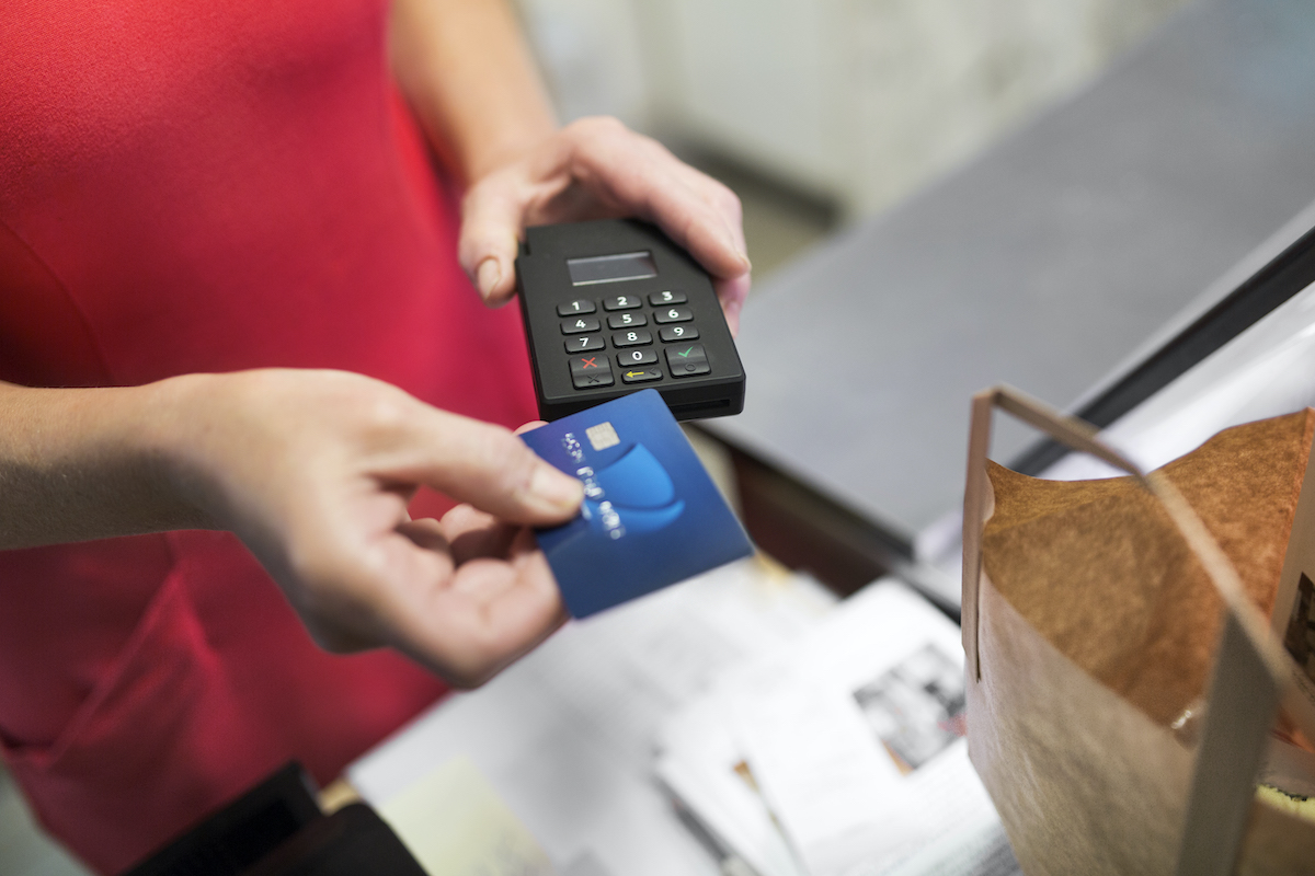 Close-up of sales clerk putting credit card in credit card reader