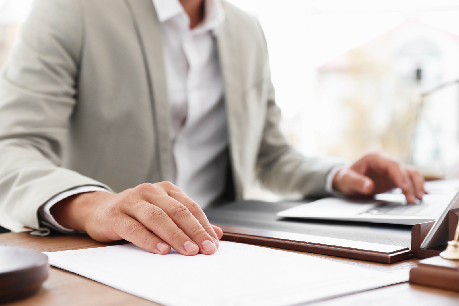Male Notary Working With Laptop At Table In Office, Closeup
