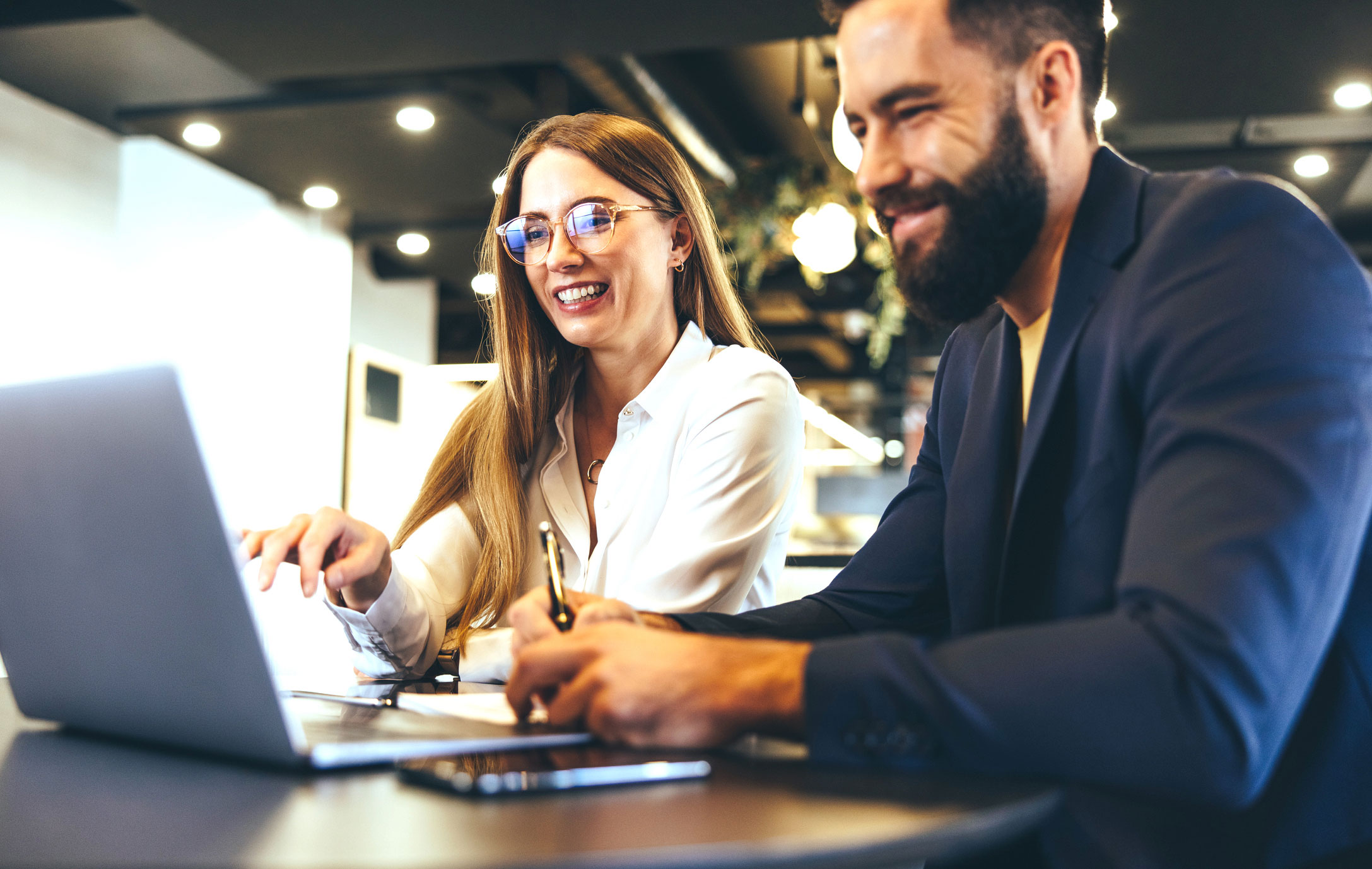 Merchant-category-page-man-and-woman-discussing-in-front-of-computer-iStock-1352833698
