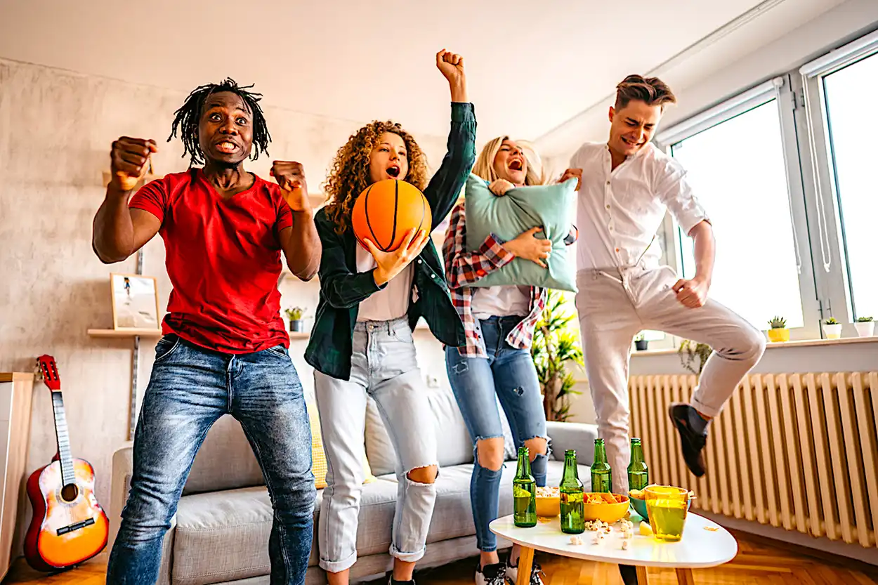 March-Madness-Payscout-iStock-1326318184 4 diverse people cheering with a basketball Payscout