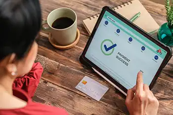 Tablet and credit card on a desk table with the words Payment Success